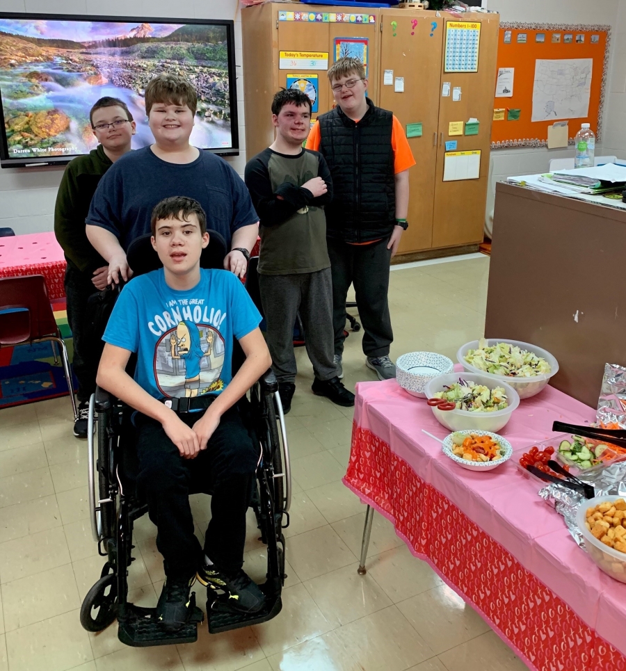 kids posing next to a table of food